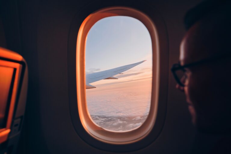 Man looking out airplane window in flight